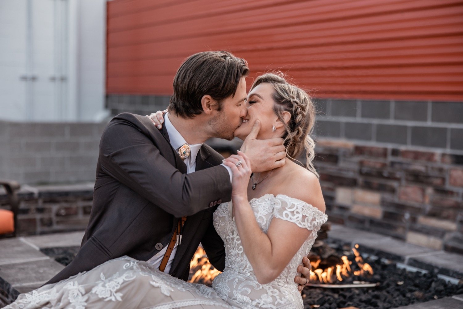A couple kissing by the Biergarten fire pit.