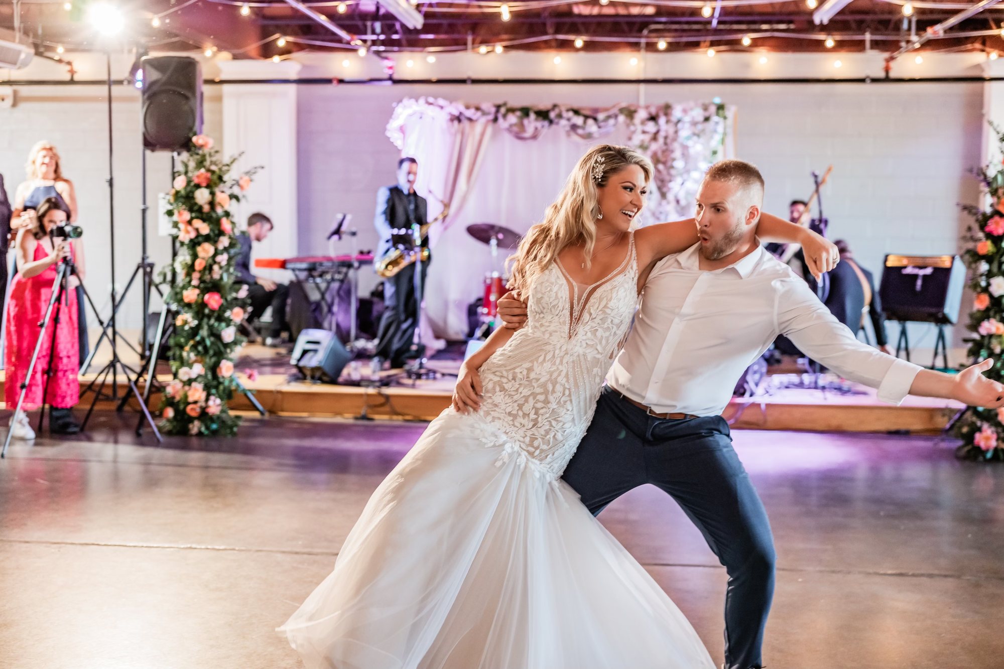 A bride and groom dancing in front of the band on the ballroom stage.